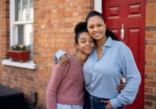 Mother and daughter outside home front door