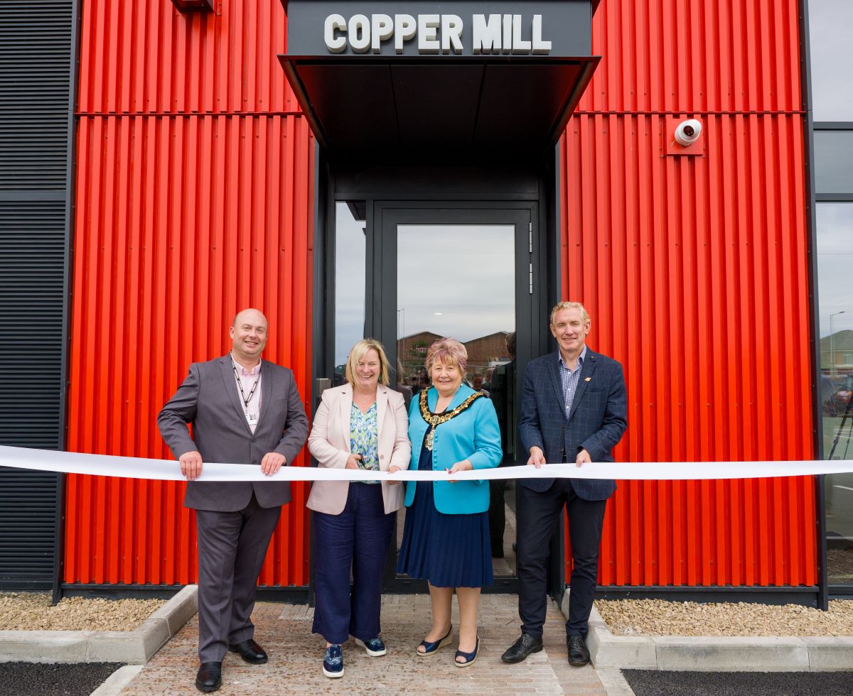 opening ceremony - four people about to cut ribbon stood in front of building