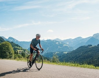 sports cyclist riding  a mountain road on sunny day